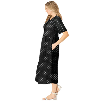 Woman wearing black polka dot button-front dress with gathered waist and flowing skirt