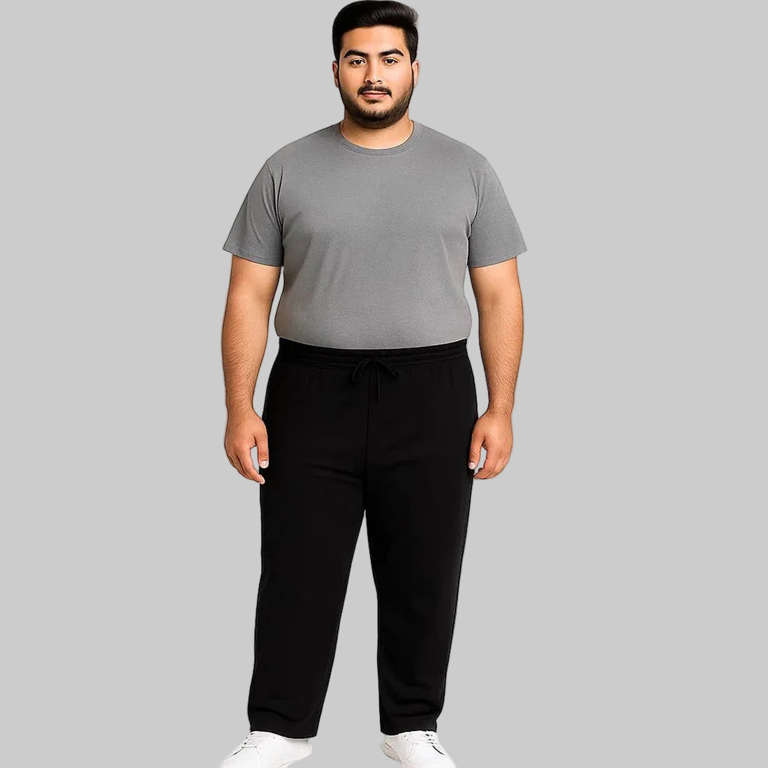 Black plus-size jogger trousers with subtle side stripe, worn by a 2XL Pakistani male model on a clean white background.
