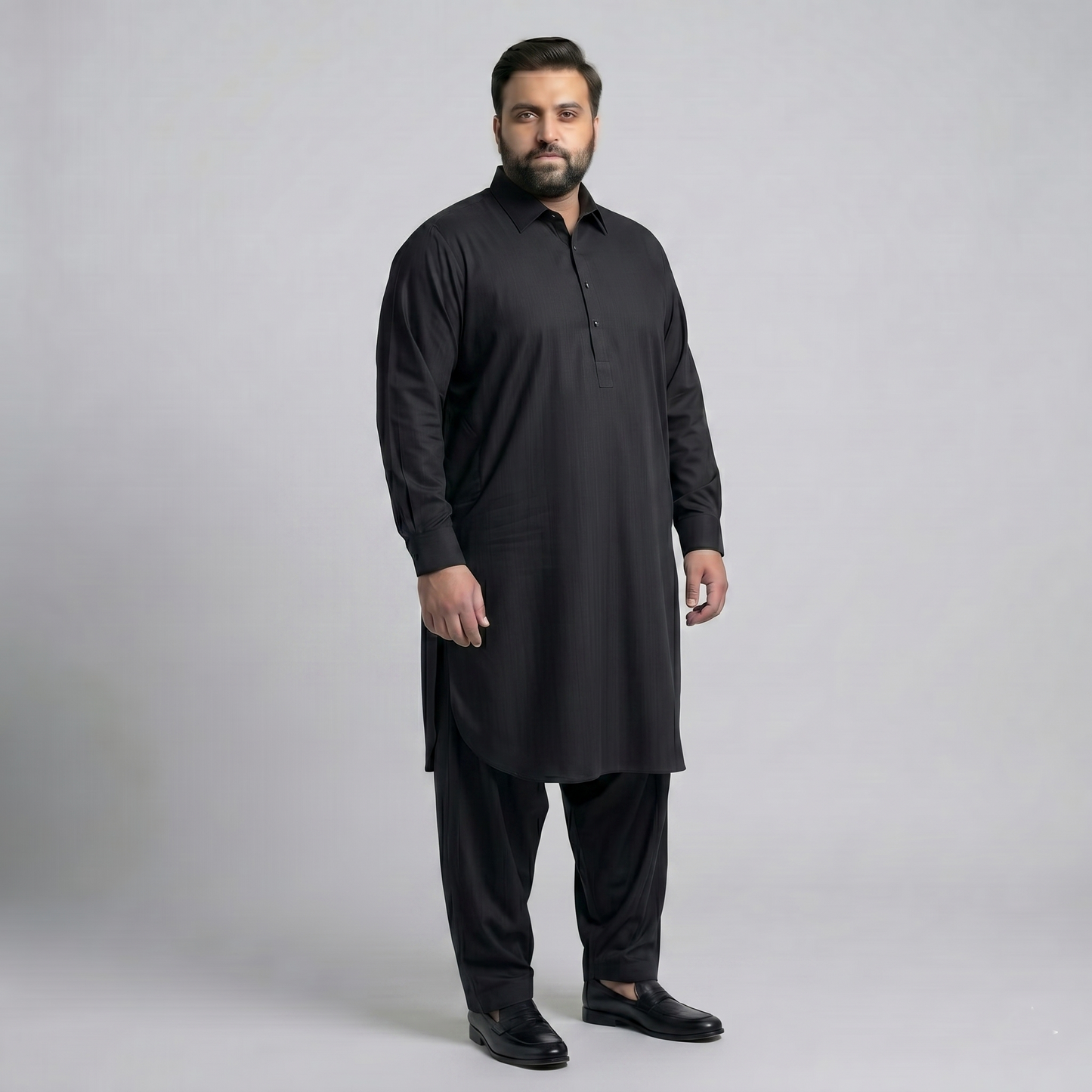 Man wearing a black kurta with pants on a gray background