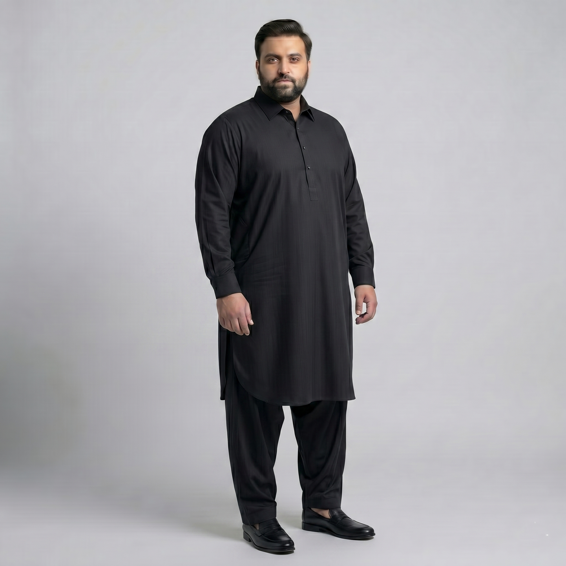 Man wearing a black kurta with pants on a gray background