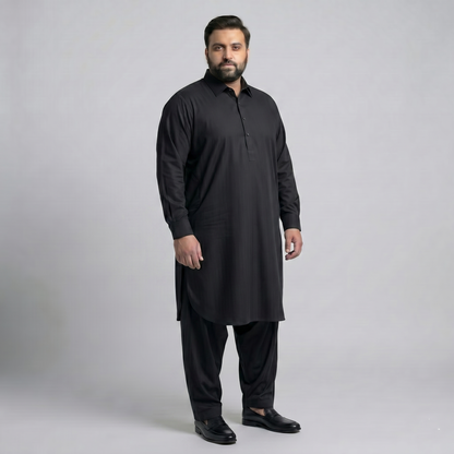 Man wearing a black kurta with pants on a gray background