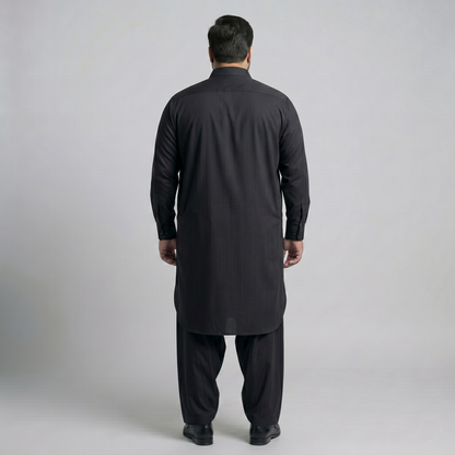 Man wearing a black kurta with pants on a light gray background