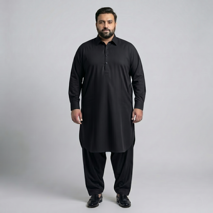 Man wearing a black traditional outfit on a gray background