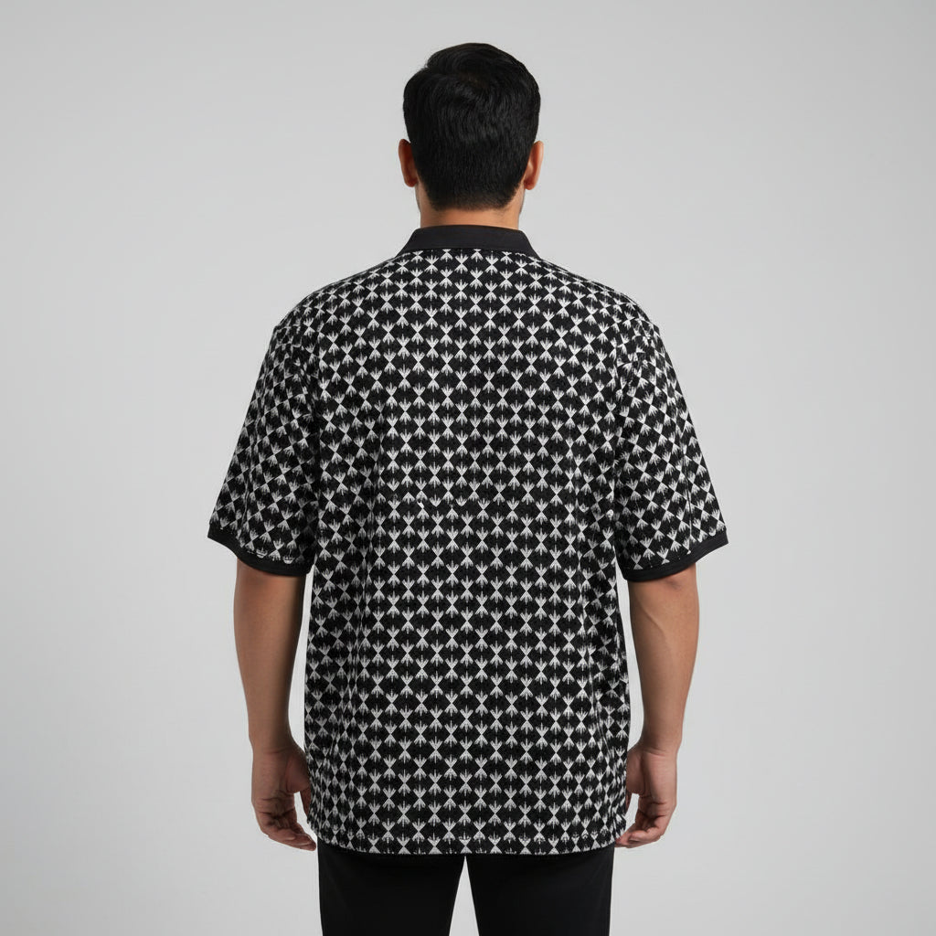 Black plus size polo shirt with white geometric print and solid black collar laid flat showing full front design