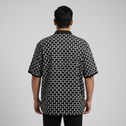 Black plus size polo shirt with white geometric print and solid black collar laid flat showing full front design