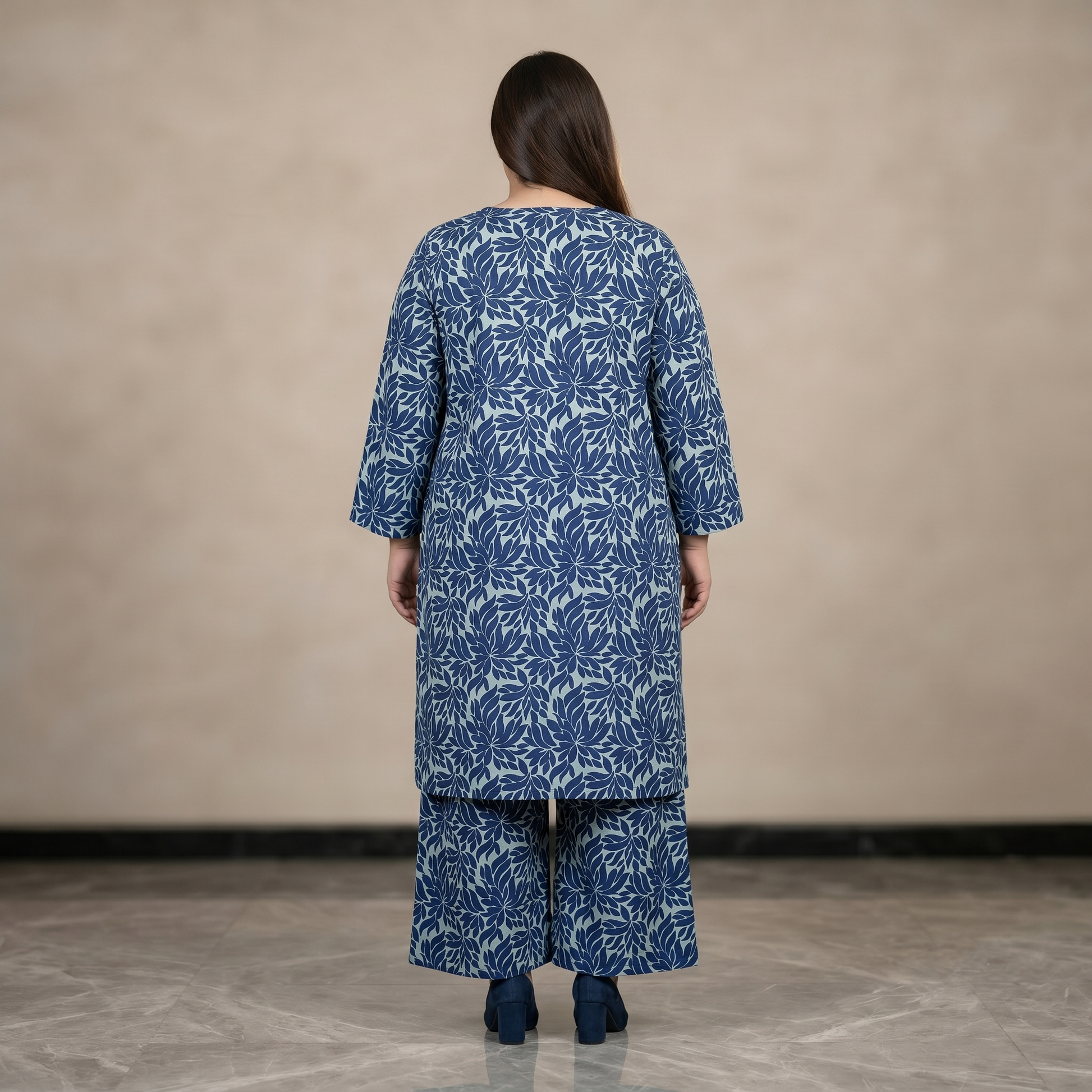 Woman wearing a blue floral patterned outfit against a beige background