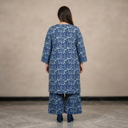 Woman wearing a blue floral patterned outfit against a beige background