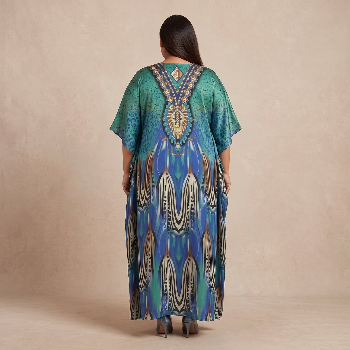Blue and teal peacock feather motif maxi kaftan made from lightweight polyester with an elegant print and flowing silhouette.