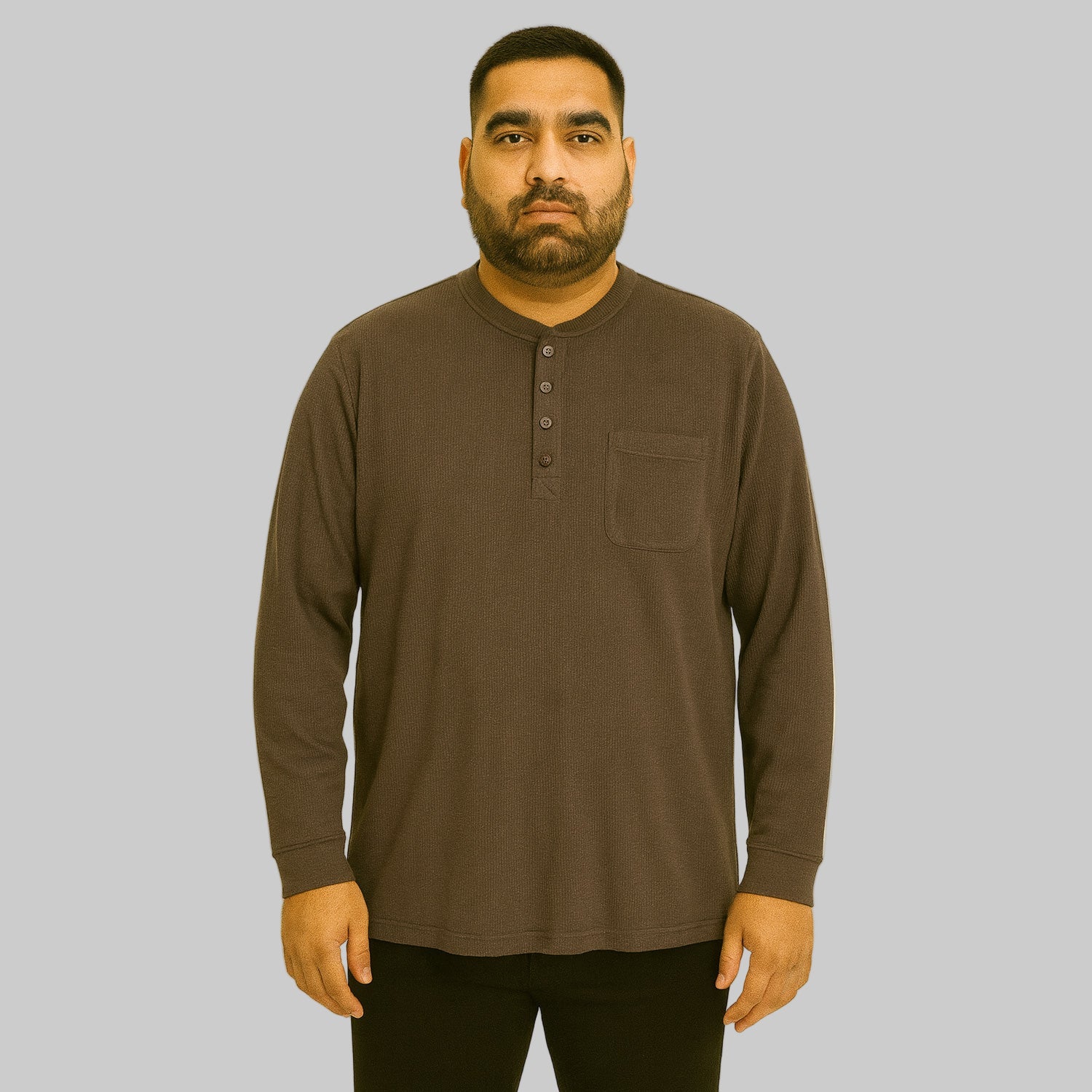 Plus-size Pakistani male model wearing brown waffle-knit thermal Henley tee on a studio background, long sleeves, relaxed fit.