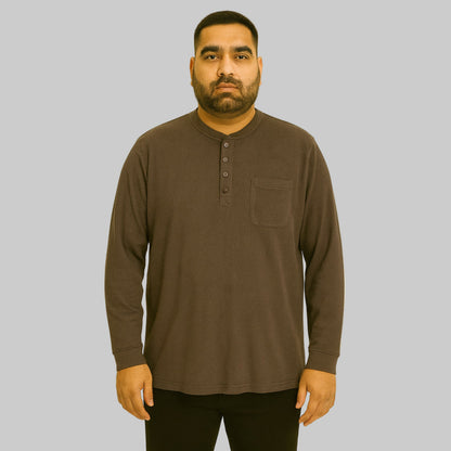 Plus-size Pakistani male model wearing brown waffle-knit thermal Henley tee on a studio background, long sleeves, relaxed fit.