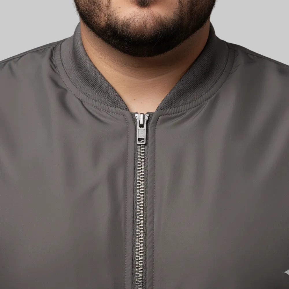 Brown plus size bomber jacket with front zip closure and ribbed cuffs on a clean background.