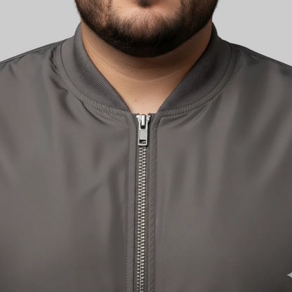 Brown plus size bomber jacket with front zip closure and ribbed cuffs on a clean background.