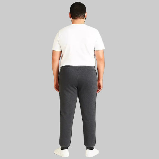 Pakistani plus size male model wearing charcoal side-striped trouser with elastic waistband and relaxed fit on white background