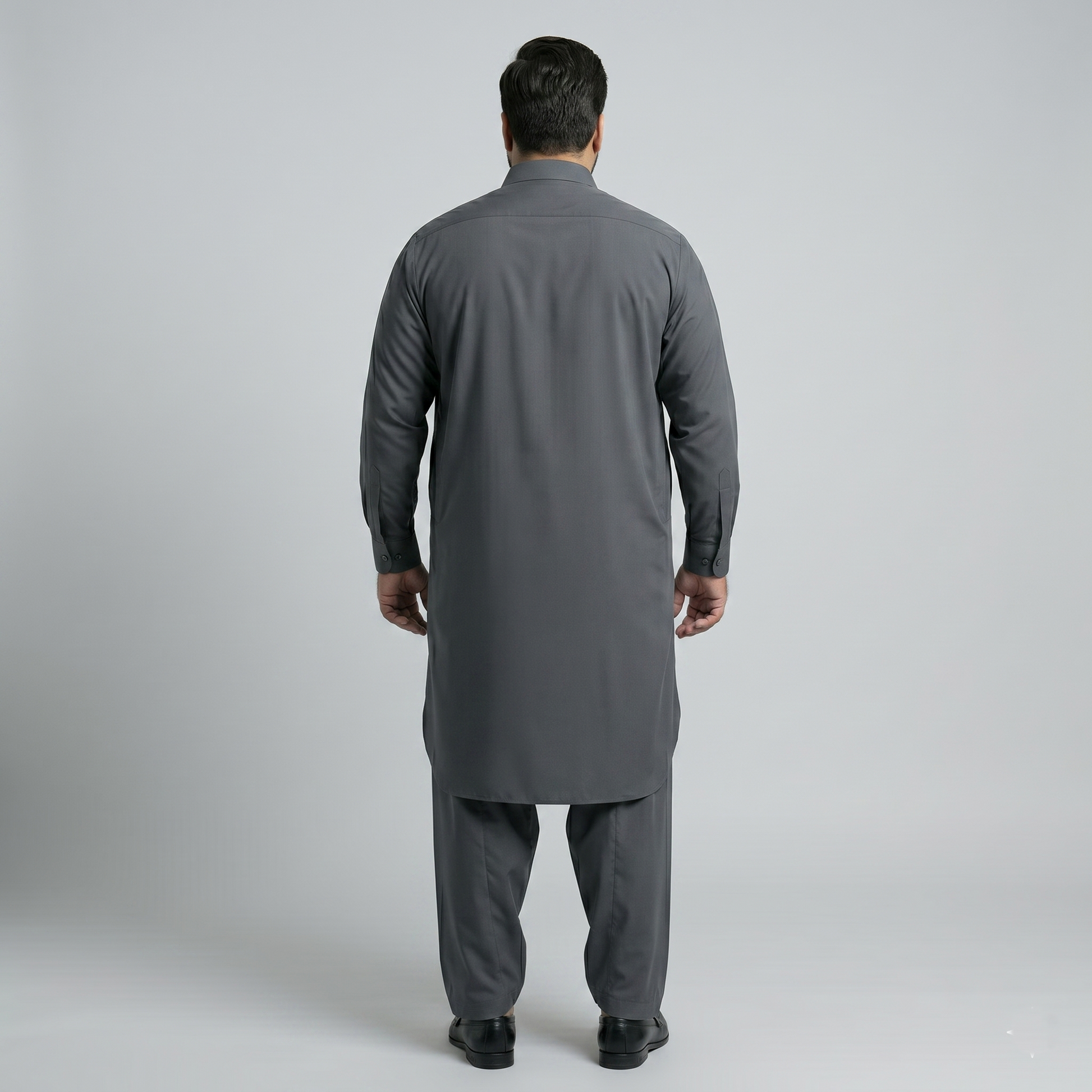 Man wearing a gray traditional outfit on a plain background