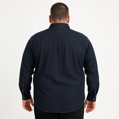 Plus-size male model wearing a dark indigo denim western shirt with chest pockets, button-down front, and long sleeves, studio shot on a clean white background.