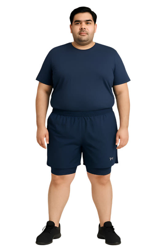 Plus-size male model wearing navy blue hybrid double-layer performance shorts with white t-shirt and sneakers