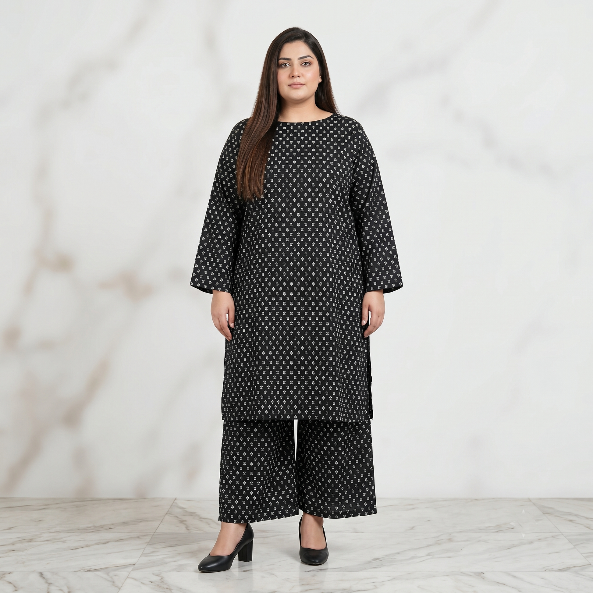 Woman wearing a black patterned outfit against a white background
