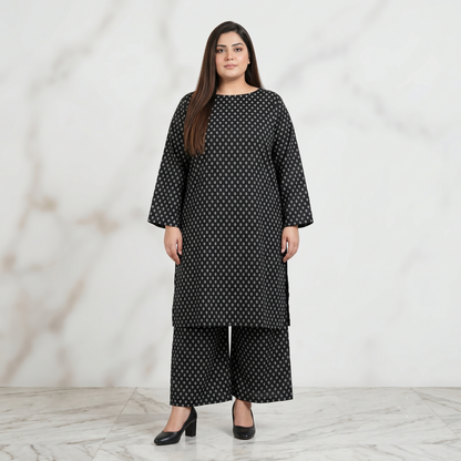 Woman wearing a black patterned outfit against a white background