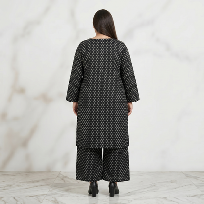 Woman wearing a black patterned outfit against a white background