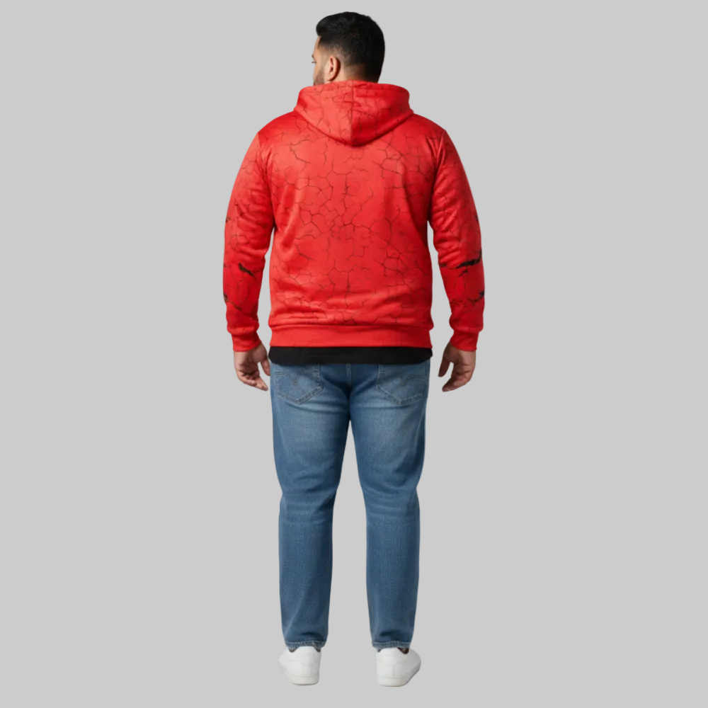 Person wearing a red hoodie and blue jeans on a gray background