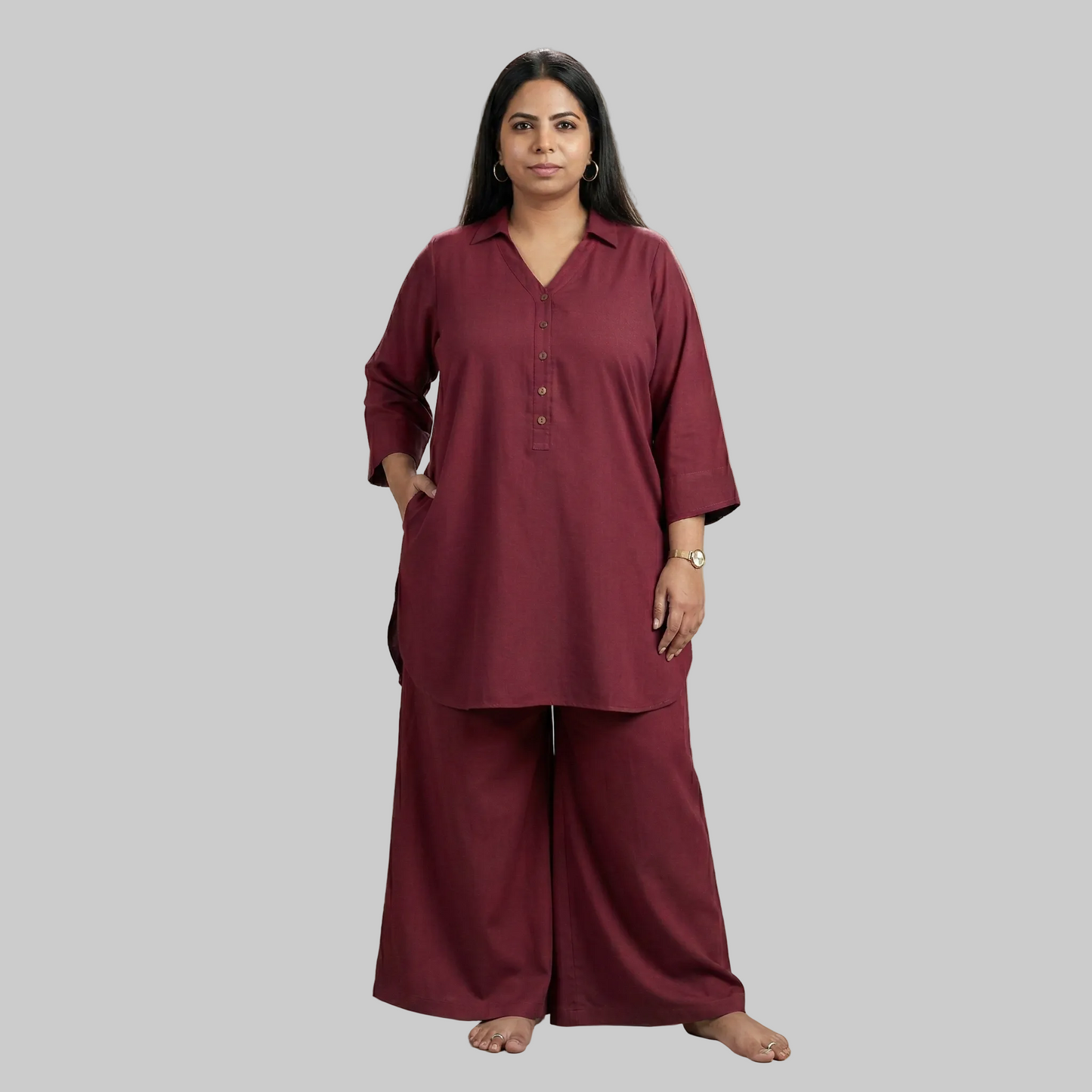 Woman wearing a maroon outfit against a neutral background