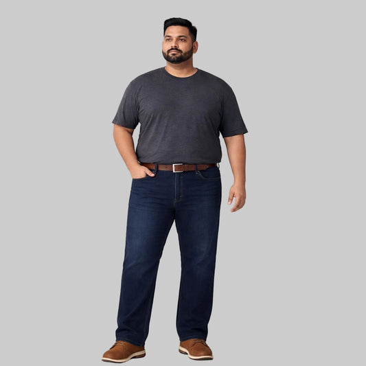 Dark blue straight fit denim jeans worn by a plus-size Pakistani male model, featuring a clean solid wash, classic five-pocket design, and a comfortable everyday fit.