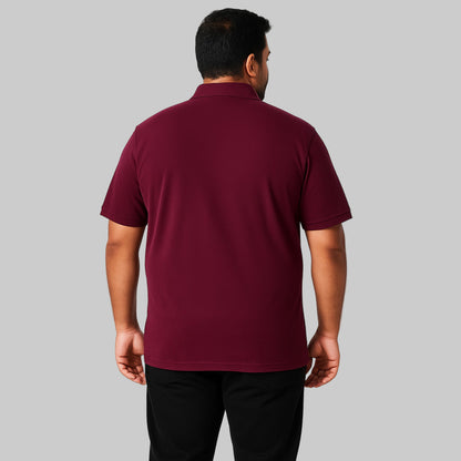 Plus-size Pakistani male model wearing dark magenta piqué polo shirt with chest pocket on a clean studio background.