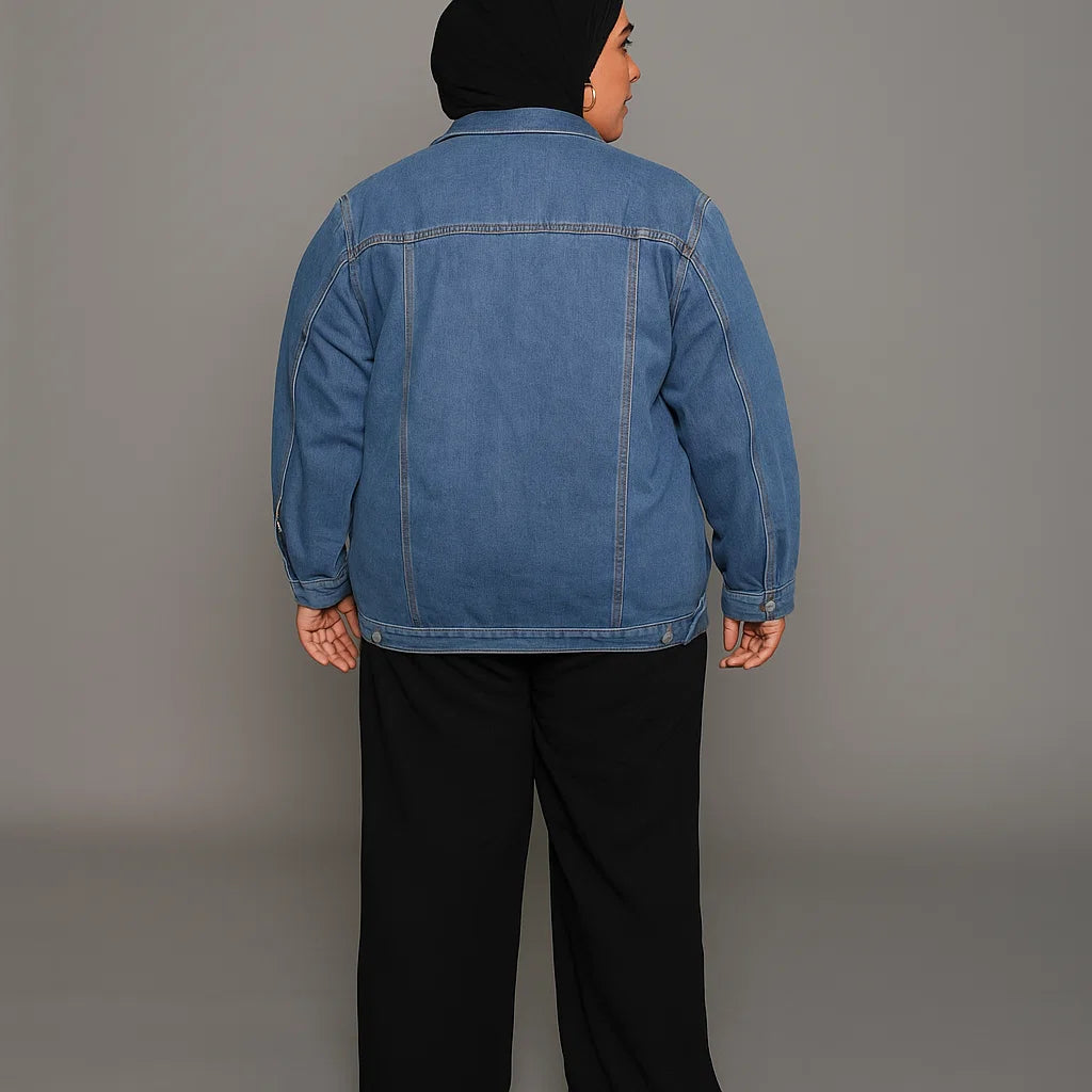 Plus-size woman wearing light wash denim jacket with flap pockets and button front

