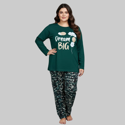 Plus-size woman wearing a forest green “Dream Big” long-sleeve pajama top with printed forest-pattern pants — cozy cotton-blend sleepwear set.
