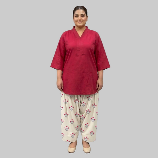 Gulnaar Farshi Shalwar Co-Ord Set Front View - Woman wearing a red top and white patterned pants on a gray background