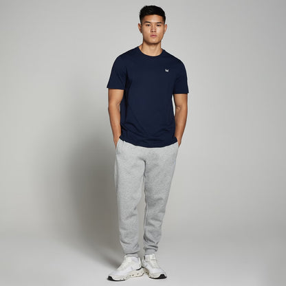 Heather grey fleece jogger pants with elastic waistband and ribbed ankle cuffs, worn by a model for casual everyday comfort.