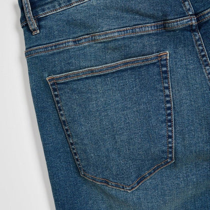 Men’s mid blue stretch slim fit denim jeans with fitted legs and clean wash, front studio view