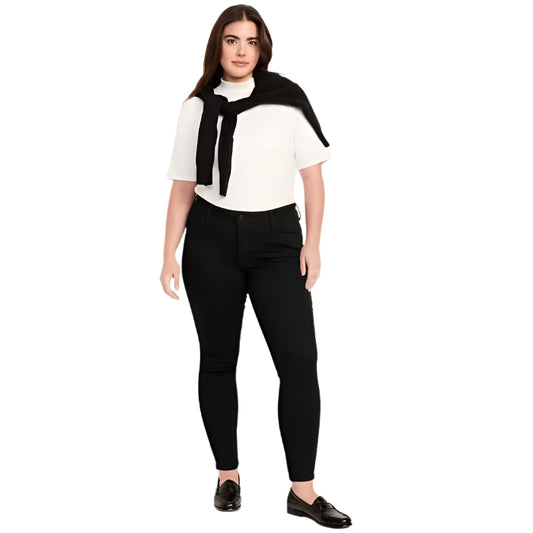 Plus-size model wearing black wash mid rise super skinny jeans with button front, zip fly, and front/back pockets, standing against a white background.