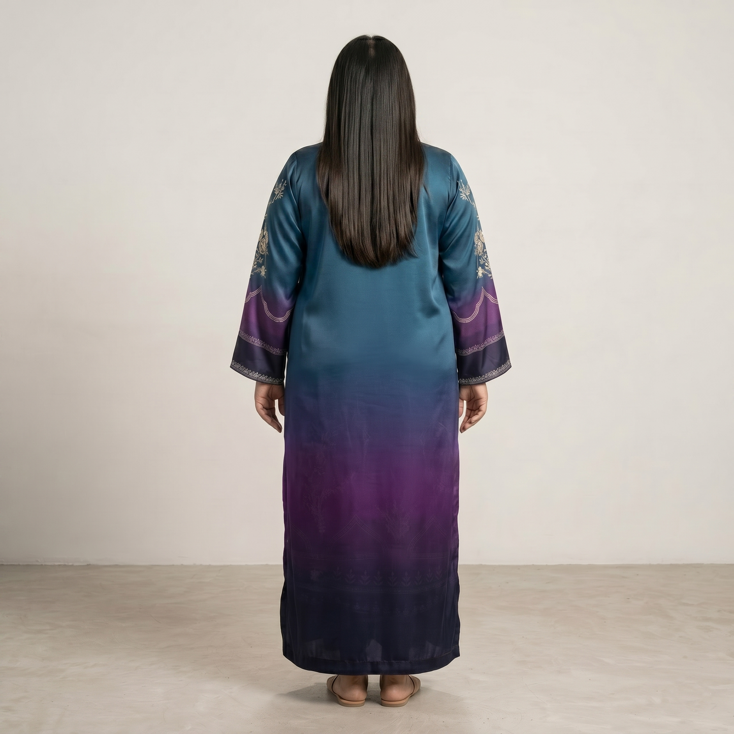Woman wearing a long, gradient kaftan dress with purple and blue colors on a plain background