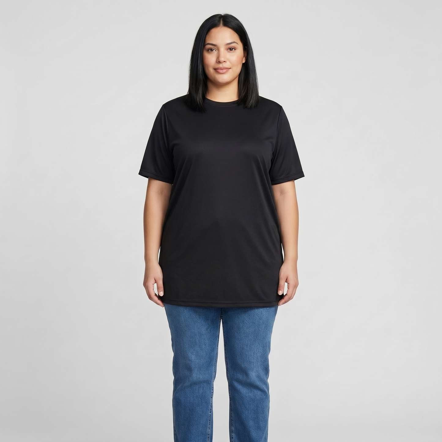 Woman wearing a black t-shirt and blue jeans on a gray background