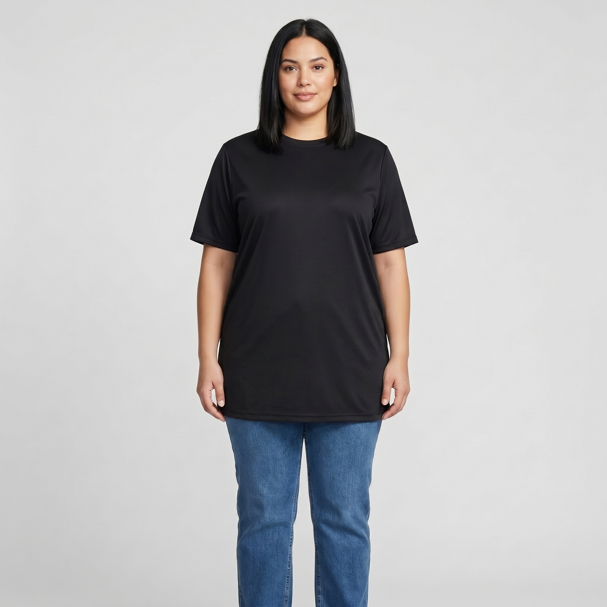 Woman wearing a black t-shirt and blue jeans on a gray background