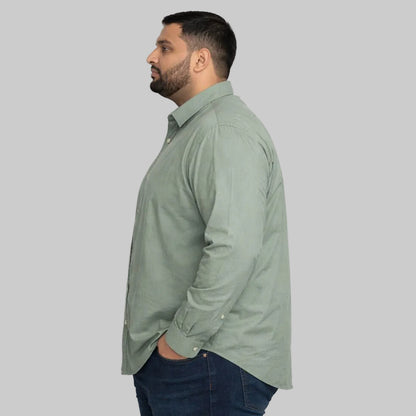 Mint green plus size casual shirt worn by a Pakistani male model in size 2XL, featuring a relaxed fit, long sleeves, button-down front, and soft breathable fabric, photographed in a studio with a clean light background.