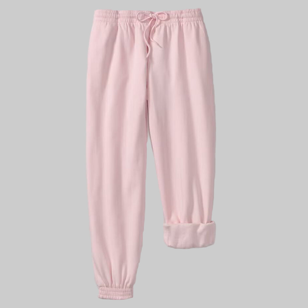 Plus-size woman wearing Misty Rose fleece jogger sweatpants with drawstring waist and elastic cuffs, styled with side pockets.