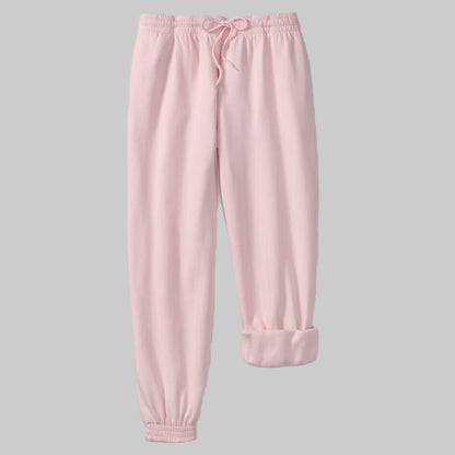 Plus-size woman wearing Misty Rose fleece jogger sweatpants with drawstring waist and elastic cuffs, styled with side pockets.