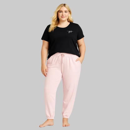 Plus-size woman wearing Misty Rose fleece jogger sweatpants with drawstring waist and elastic cuffs, styled with side pockets.