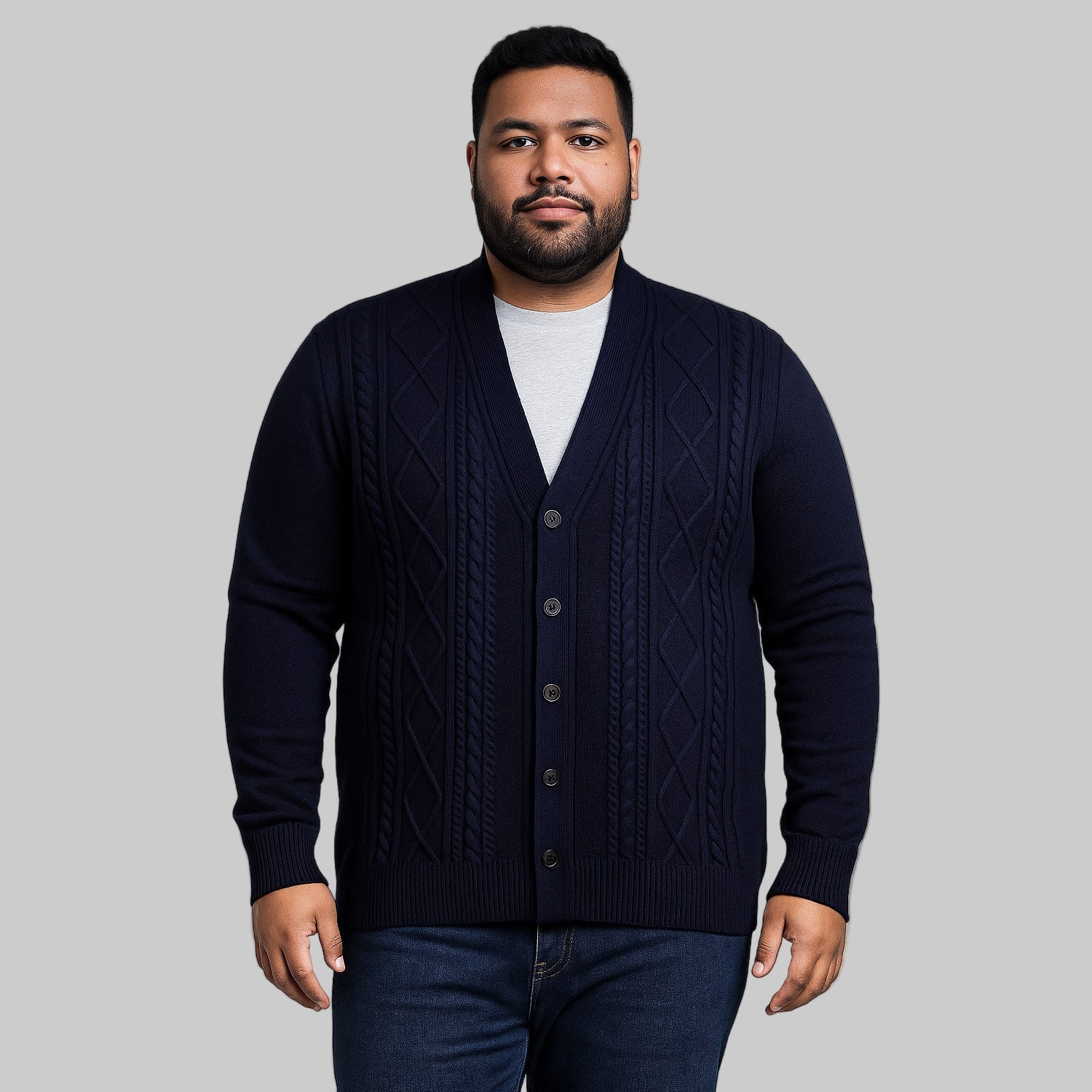 Unisex plus-size model wearing a Navy Diamond Cable Knit Cardigan Sweater made from 7G acrylic with a button-down front.