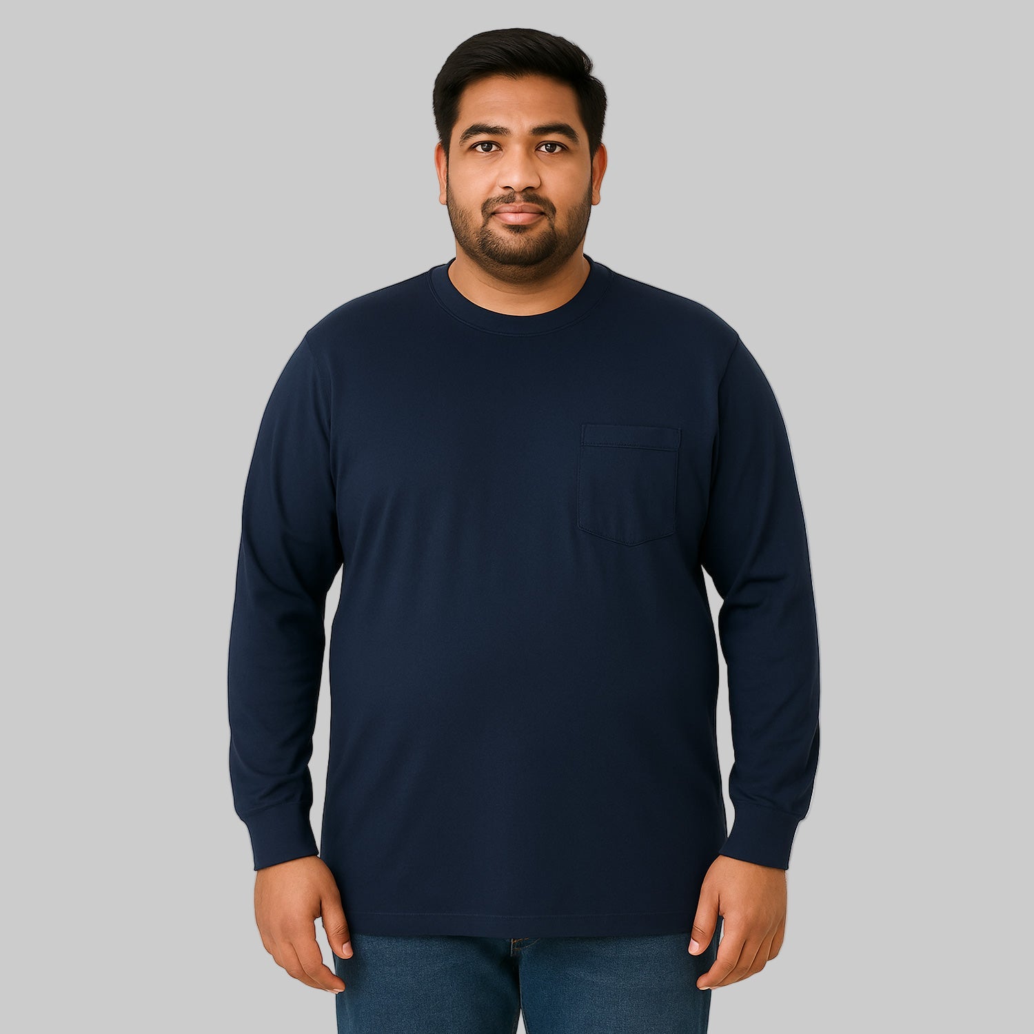 Plus-size male model wearing navy long sleeve pocket T-shirt, relaxed fit, front view, studio background.