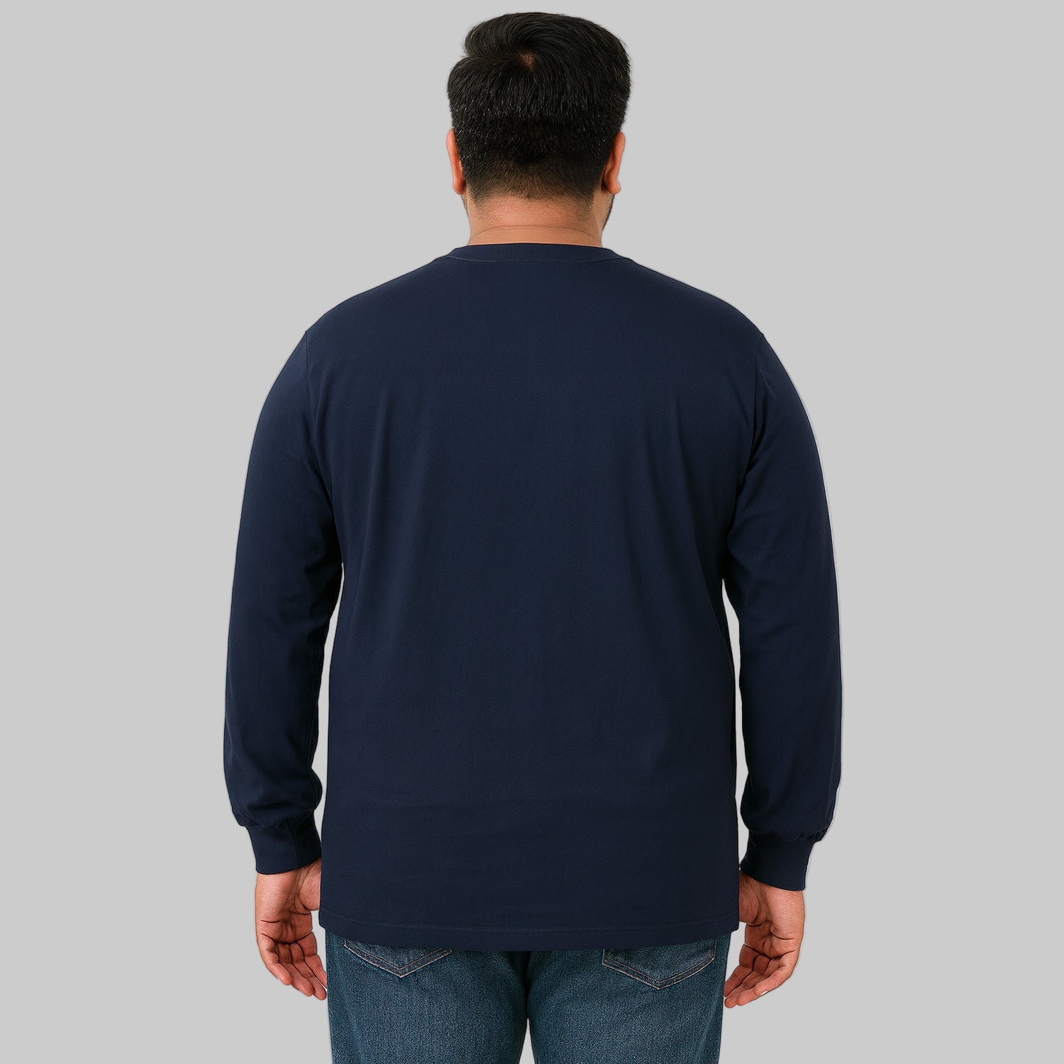 Plus-size male model wearing navy long sleeve pocket T-shirt, relaxed fit, front view, studio background.