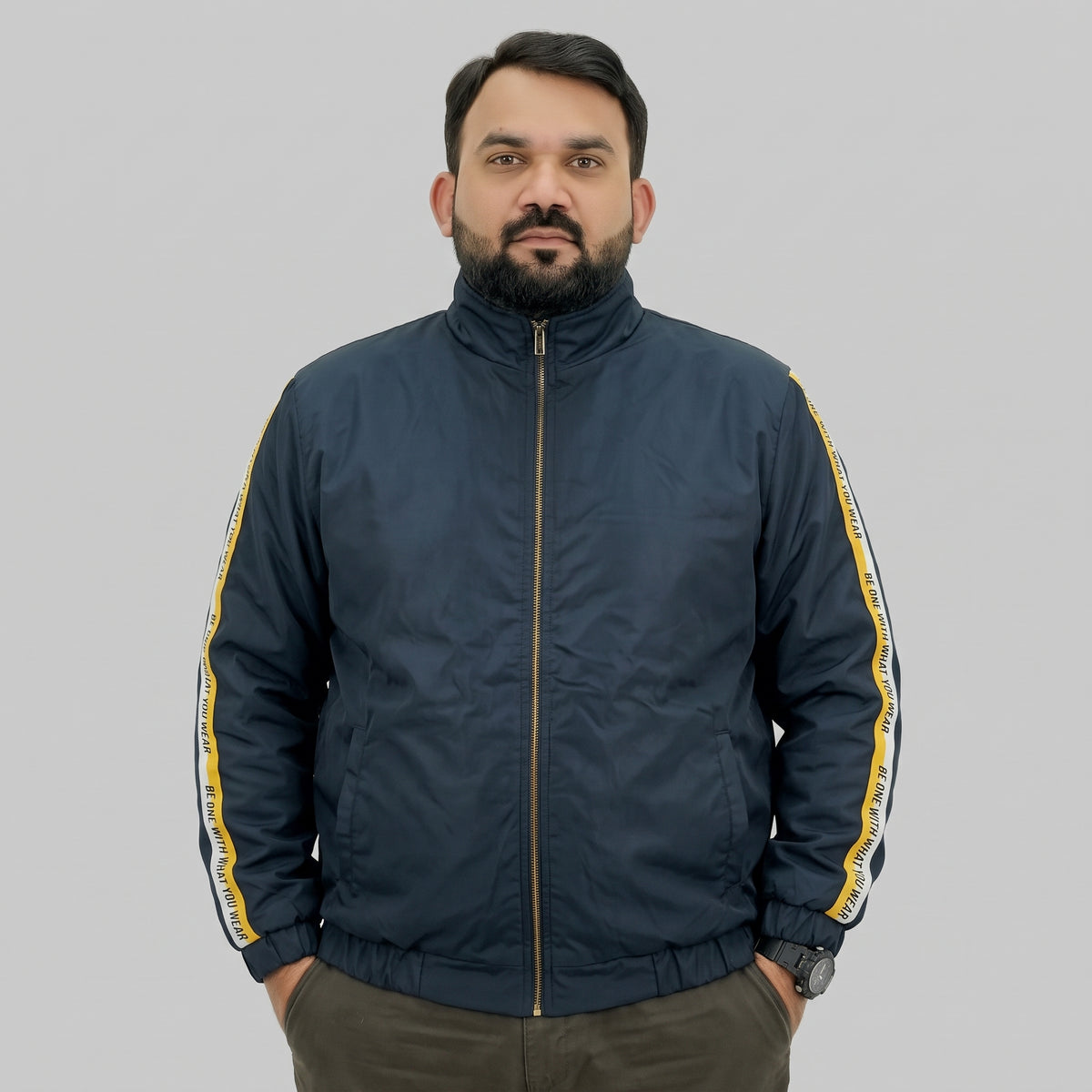  Navy blue polyester jacket with yellow and white side stripes printed with “BE ONE WITH WHAT YOU WEAR” text.