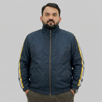 Navy blue polyester jacket with yellow and white side stripes printed with “BE ONE WITH WHAT YOU WEAR” text.