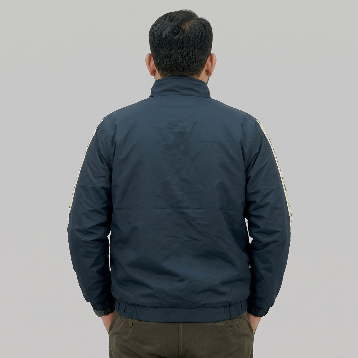  Navy blue polyester jacket with yellow and white side stripes printed with “BE ONE WITH WHAT YOU WEAR” text. 
