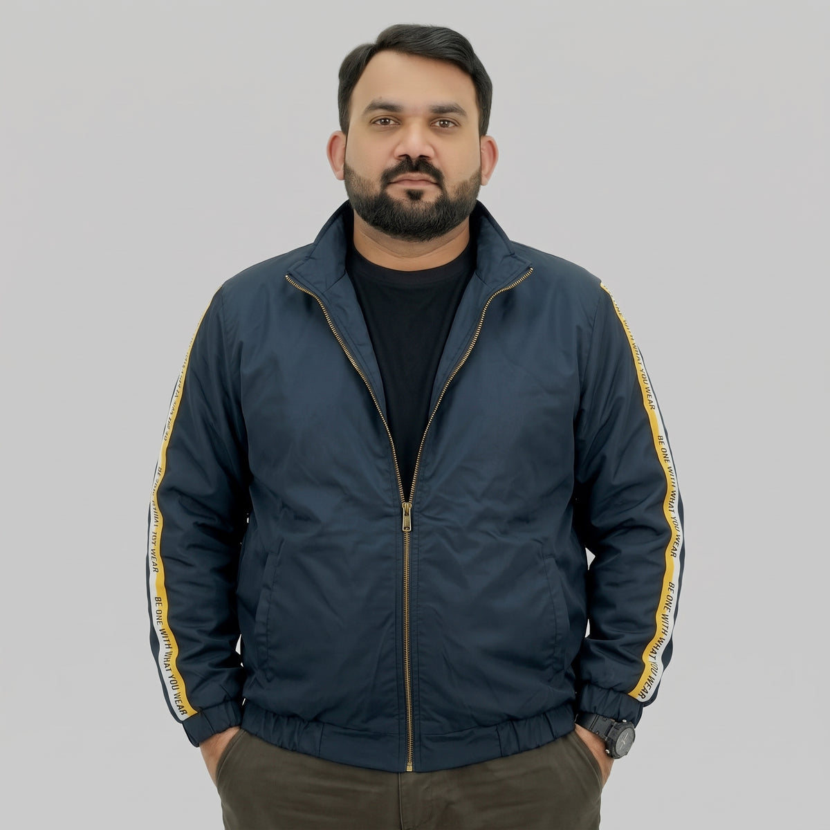  Navy blue polyester jacket with yellow and white side stripes printed with “BE ONE WITH WHAT YOU WEAR” text.