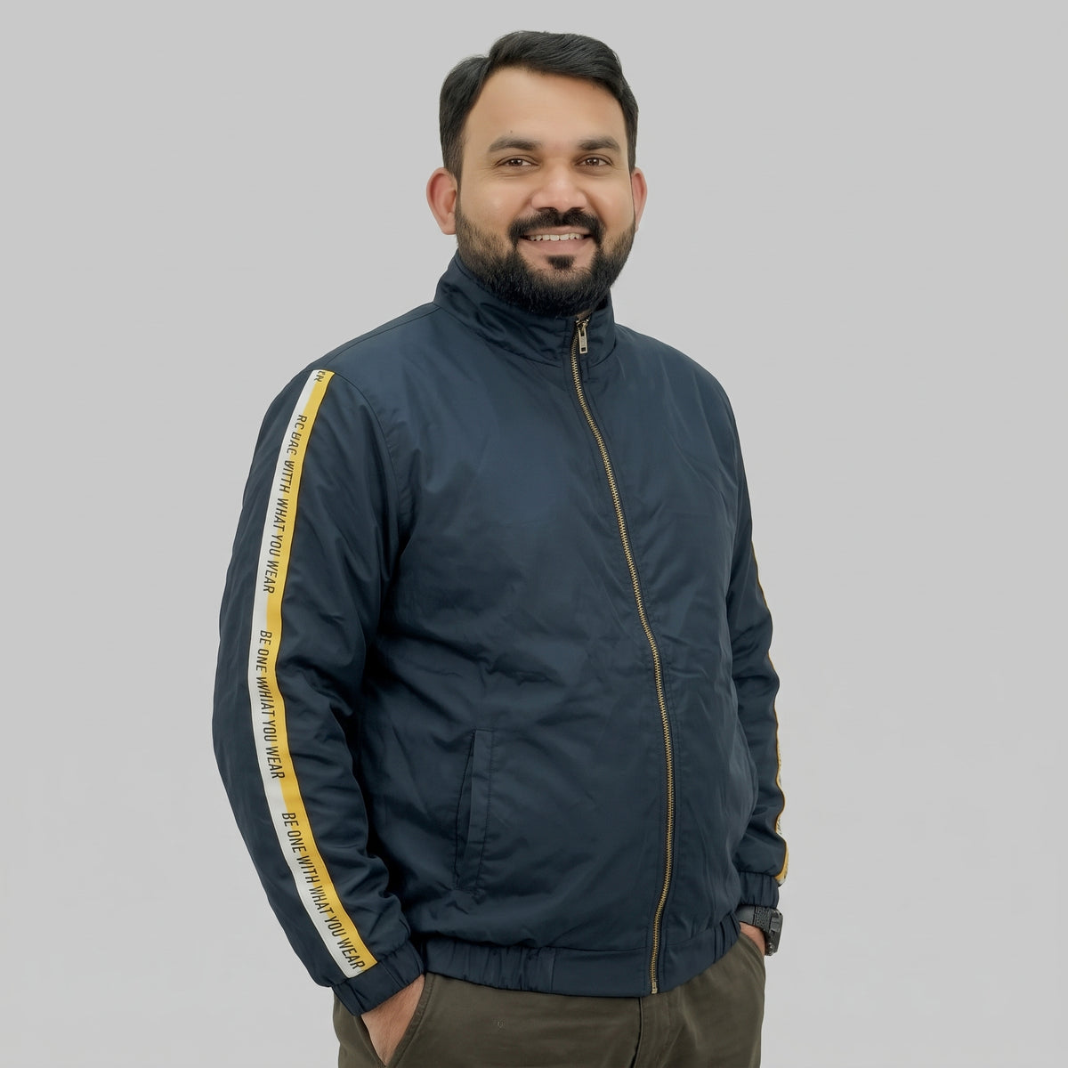  Navy blue polyester jacket with yellow and white side stripes printed with “BE ONE WITH WHAT YOU WEAR” text.