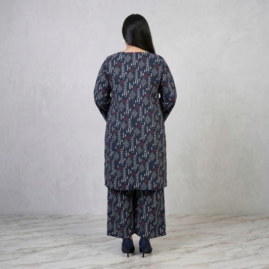 Woman wearing a patterned outfit standing against a plain background