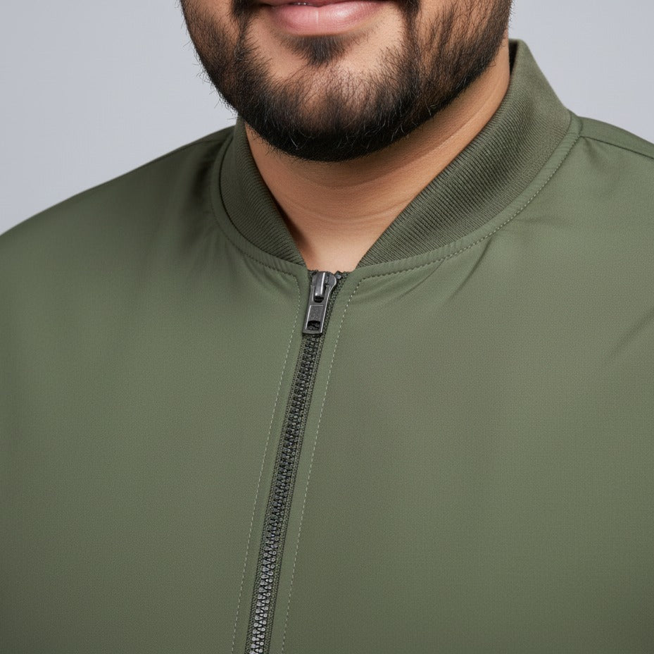 Olive plus size bomber jacket with front zip closure and ribbed cuffs on a plain background.
